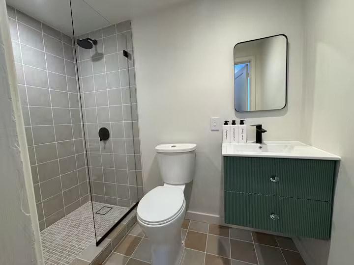 Bathroom with walk-in shower and olive vanity
